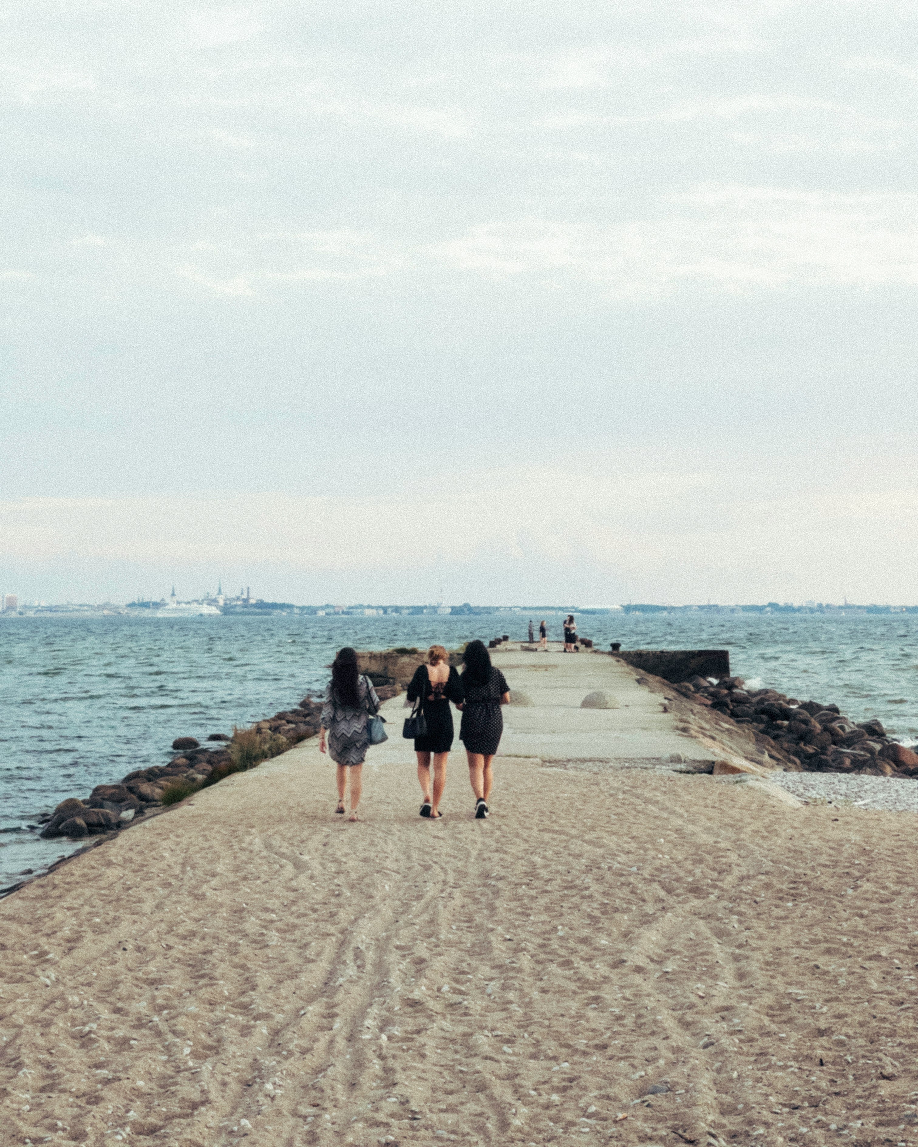 2 women walking on beach during daytime